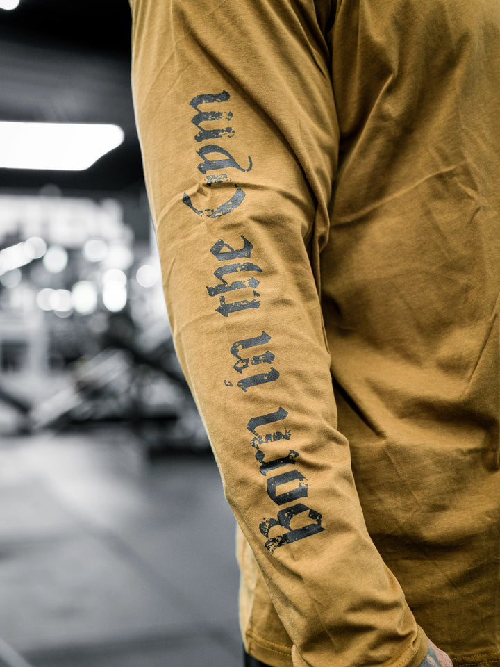 Bodybuilder Ben Chow wearing a black long-sleeve shirt with text in a gym setting#color_texas-clay