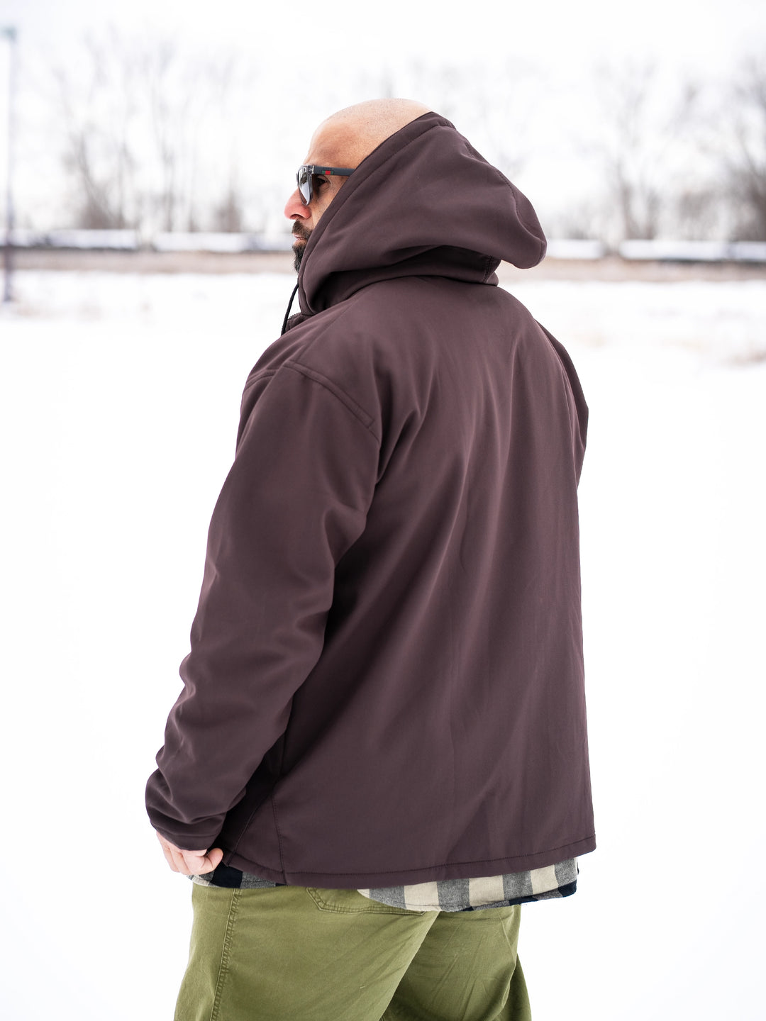 Bodybuilder wearing the Forged Jacket outdoors#color_brown