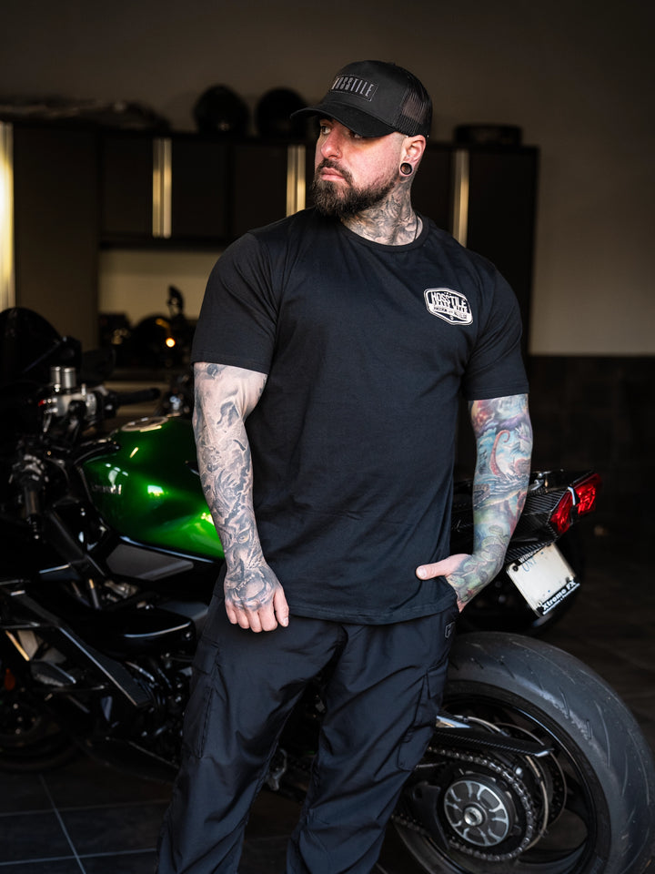 Bodybuilder wearing the Hosstile Garage Tee#color_black