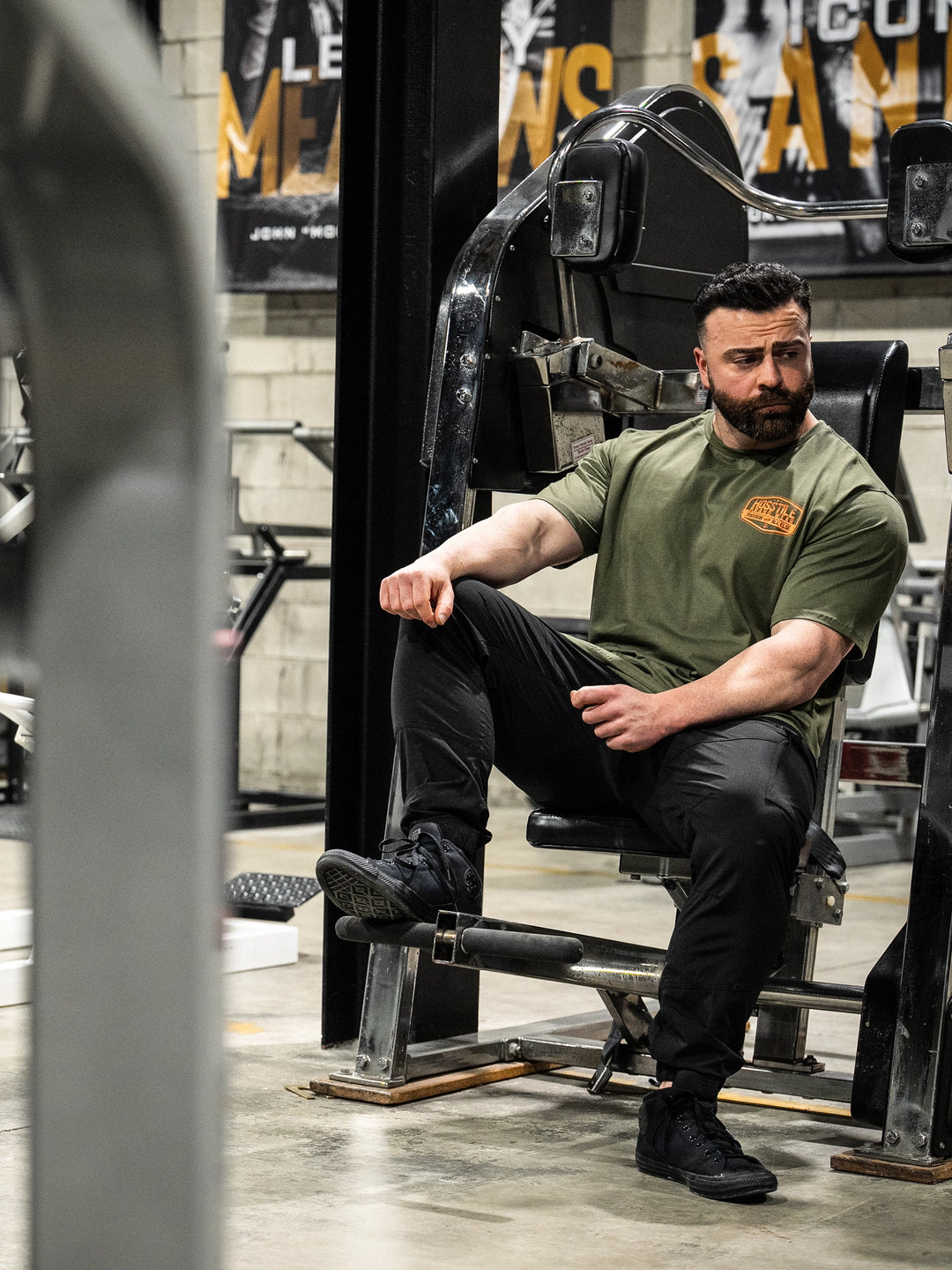 Bodybuilder wearing the Hosstile Garage Tee#color_military-green