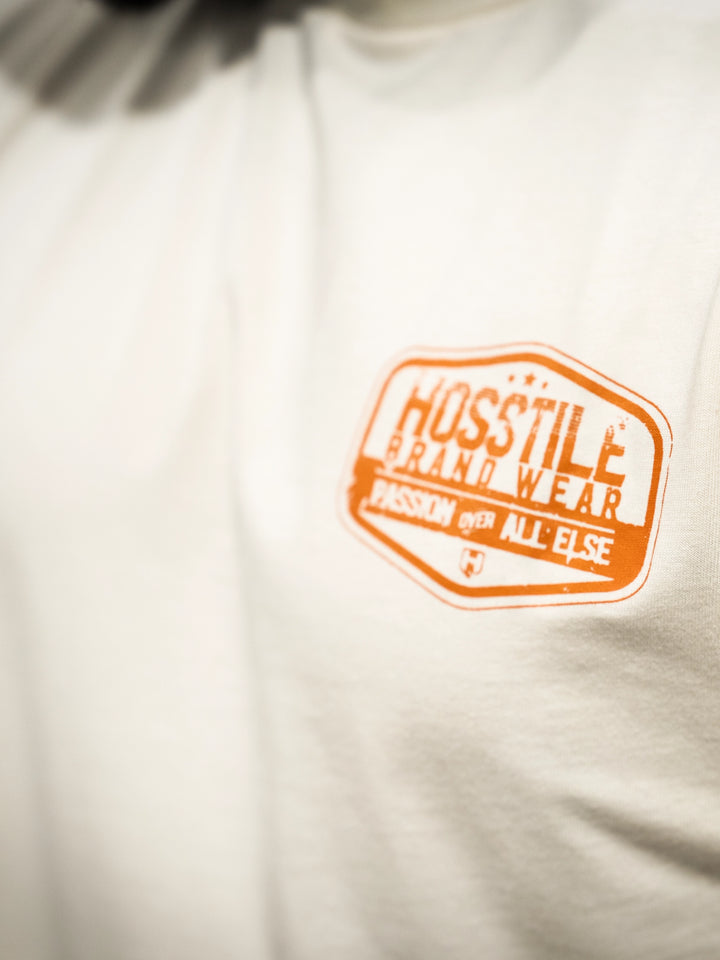 Bodybuilder wearing the Hosstile Garage Tee#color_sand