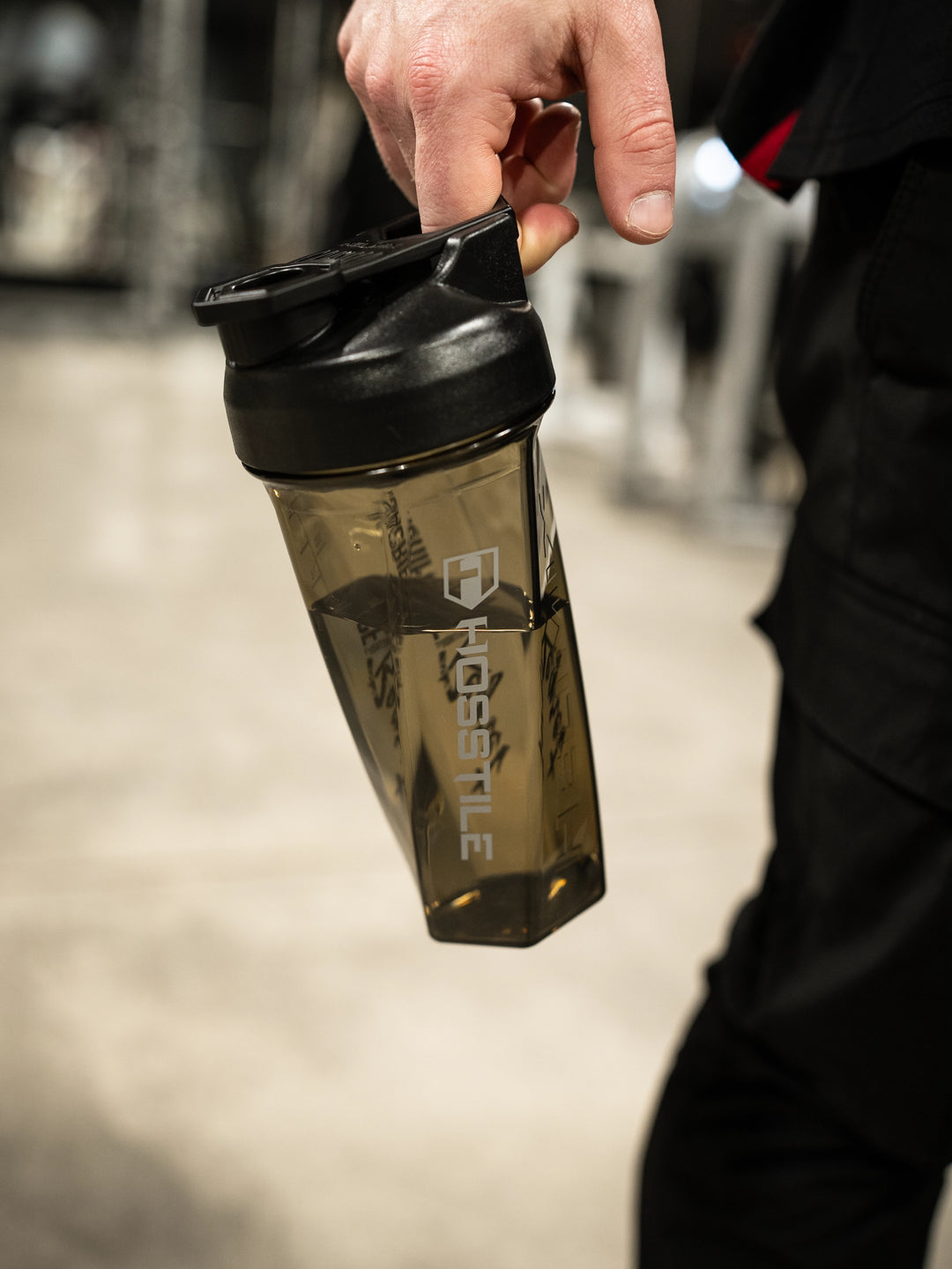 Bodybuilder carrying the Hosstile Helimix shaker cup in the gym