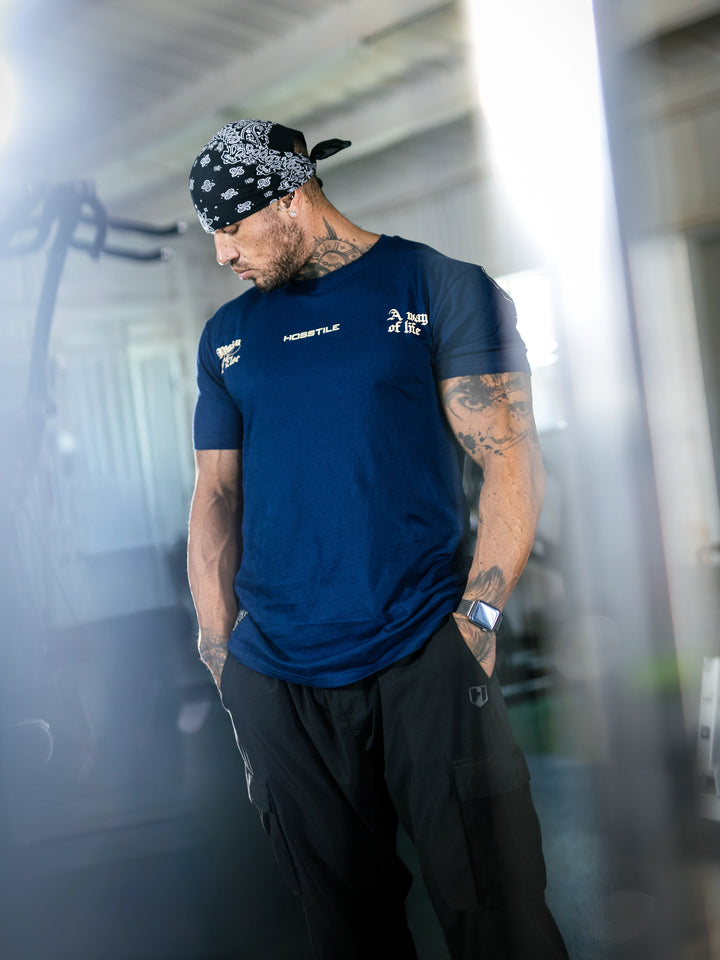 Bodybuilder Ben Chow standing in a gym wearing a t-shirt with text and graphics.#color_navy