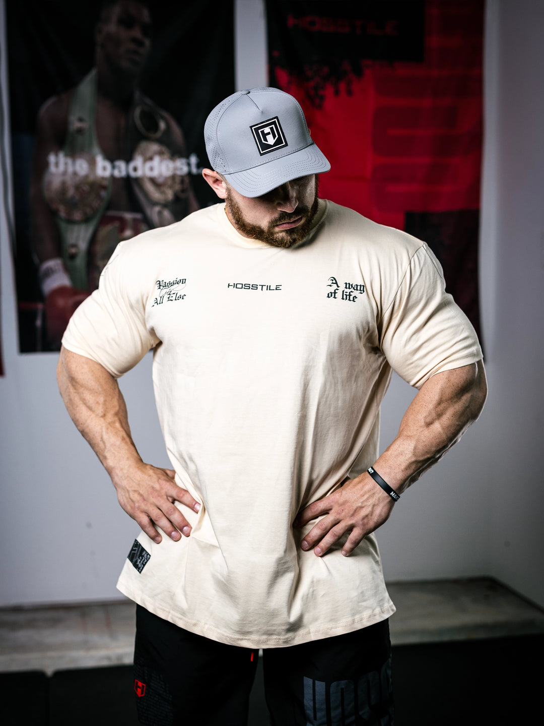 Bodybuilder Martin Fitzwater standing in a gym wearing a t-shirt with text and graphics.#color_off-white