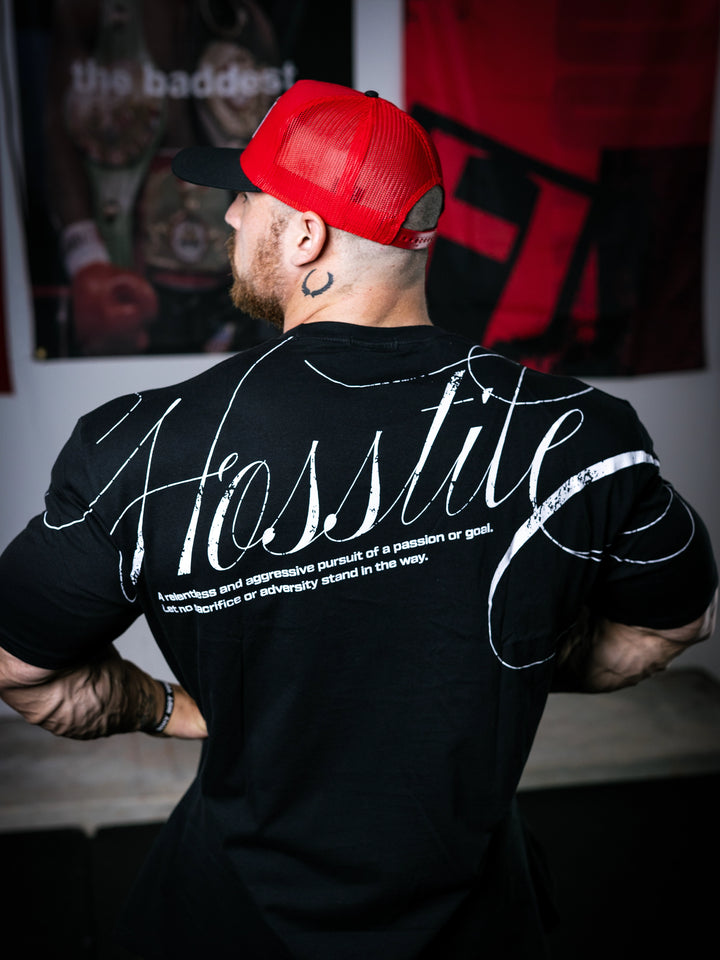 Bodybuilder Martin Fitzwater standing in a gym wearing a t-shirt with text and graphics.#color_black