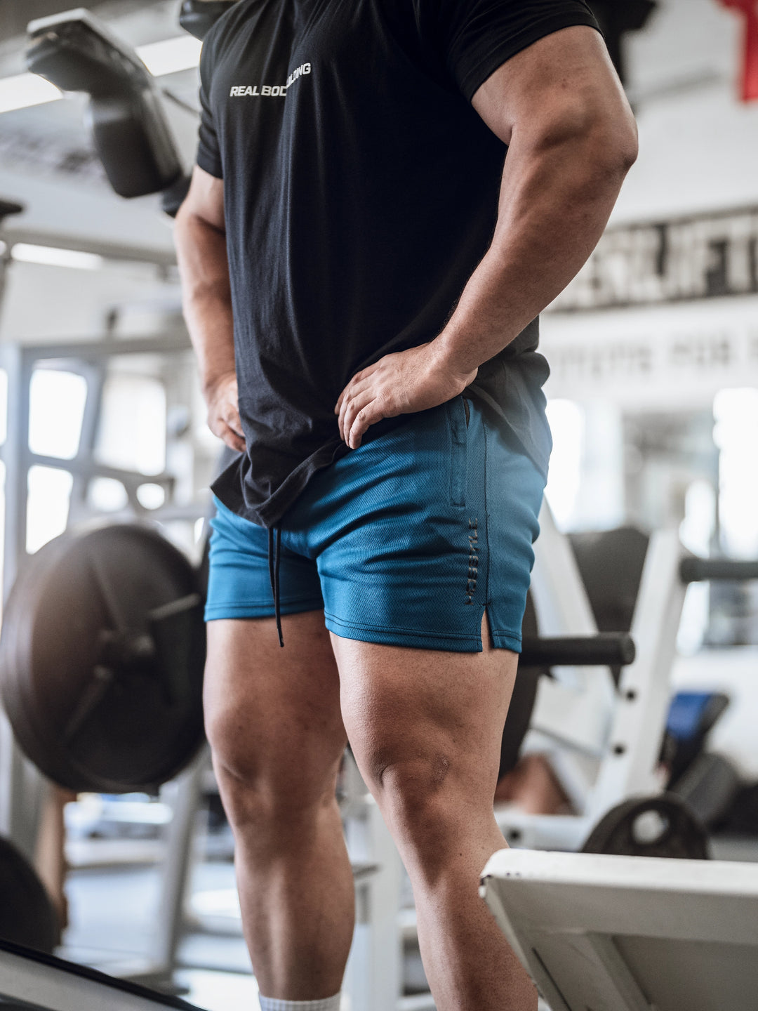 Bodybuilder in gym wearing men's mesh training shorts#color_midnight-blue