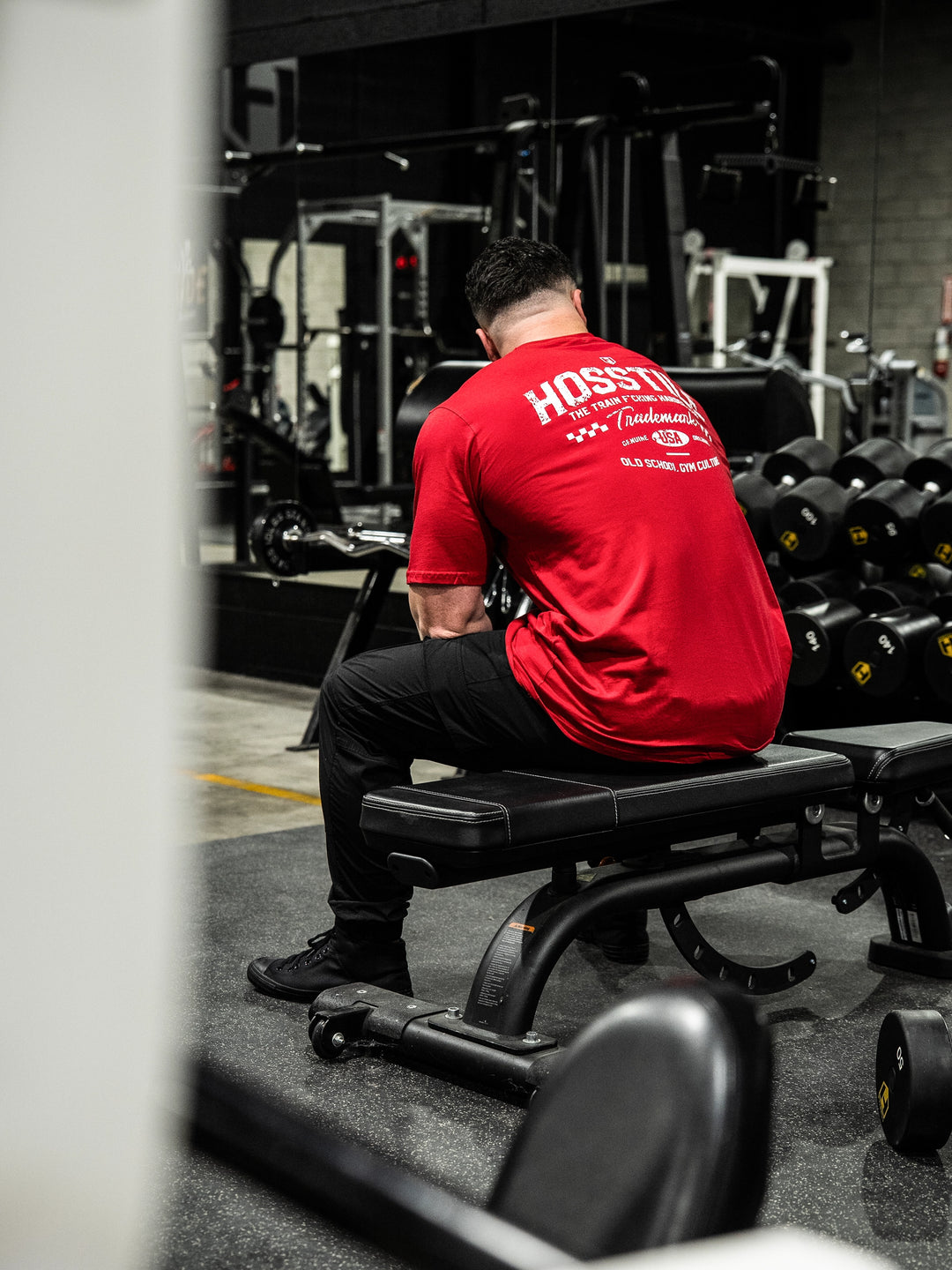Bodybuilder wearing the Hosstile Club Work Tee#color_red