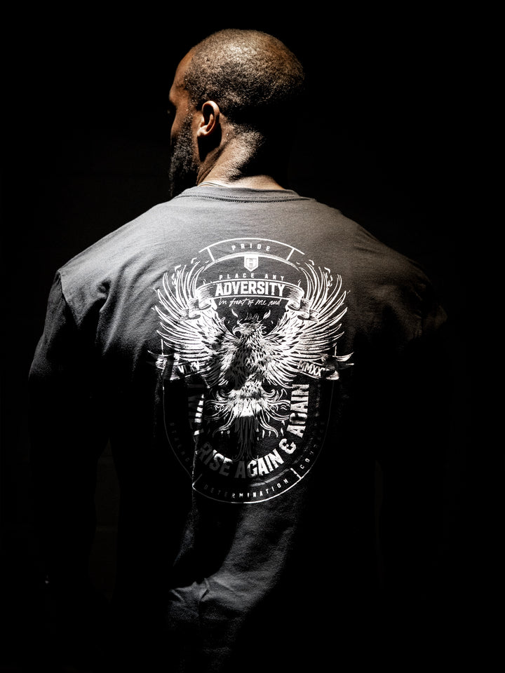Person wearing a dark shirt with a white graphic design on the back against a black background#color_black