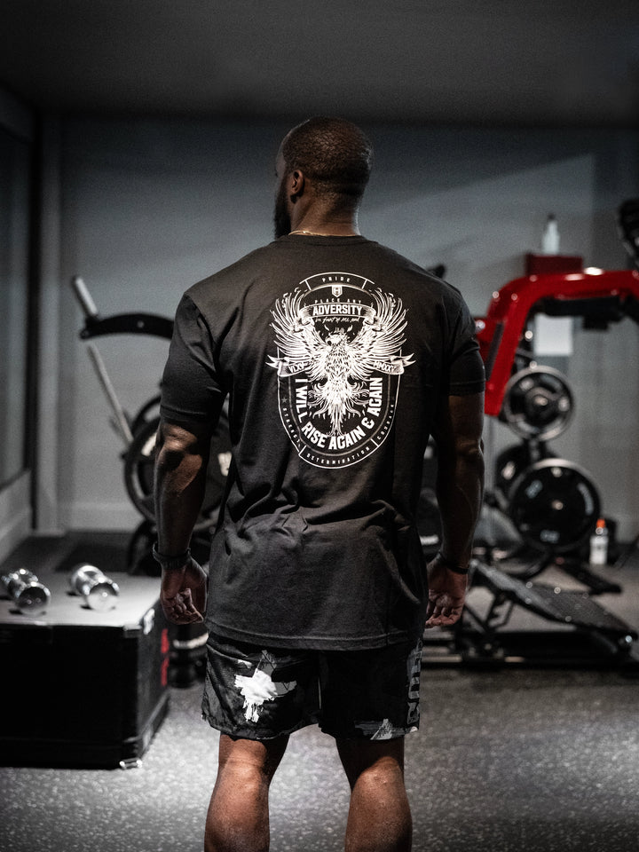 Person wearing a black t-shirt with a logo in a gym setting#color_black