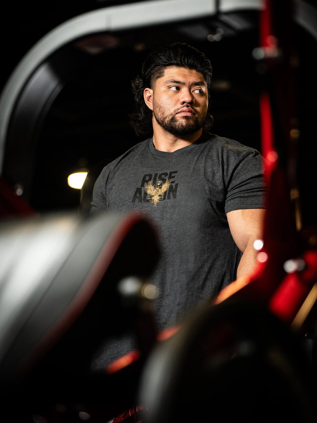 Man wearing a black t-shirt with 'Rise Above' text in a dark setting#color_charcoal