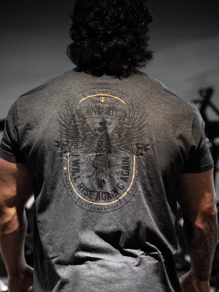 Person wearing a gray t-shirt with an eagle design and text on the back, standing against a dark background#color_charcoal