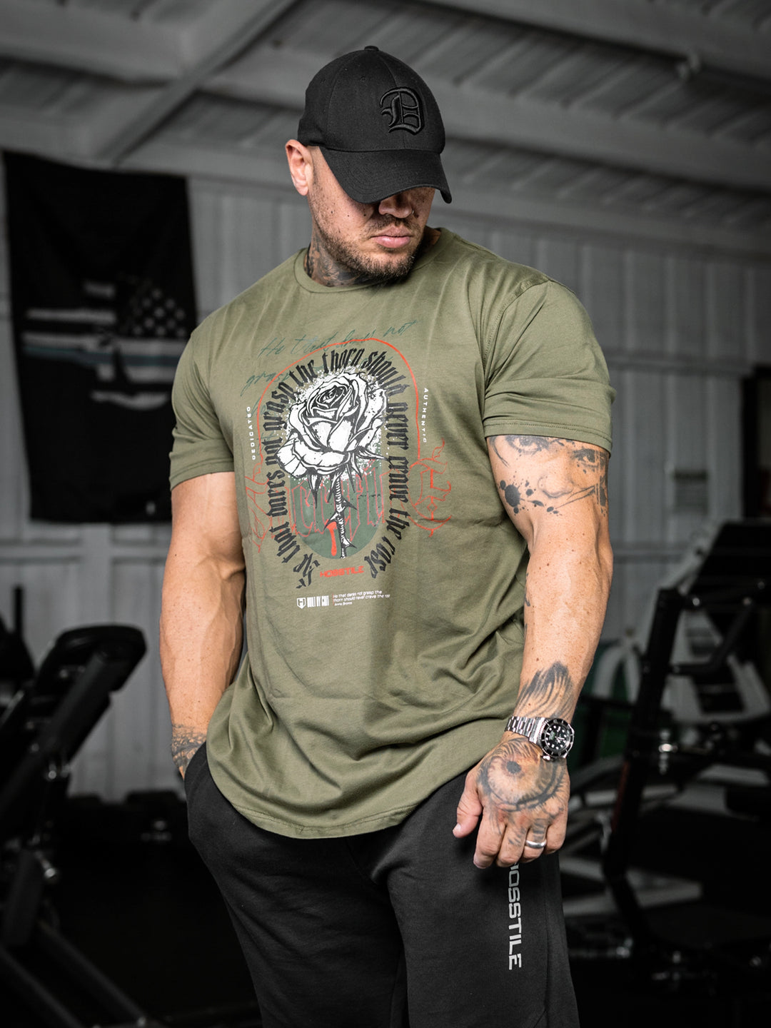 bodybuilder wearing the Rose & Thorn Men's Graphic Gym T-Shirt#color_military-green