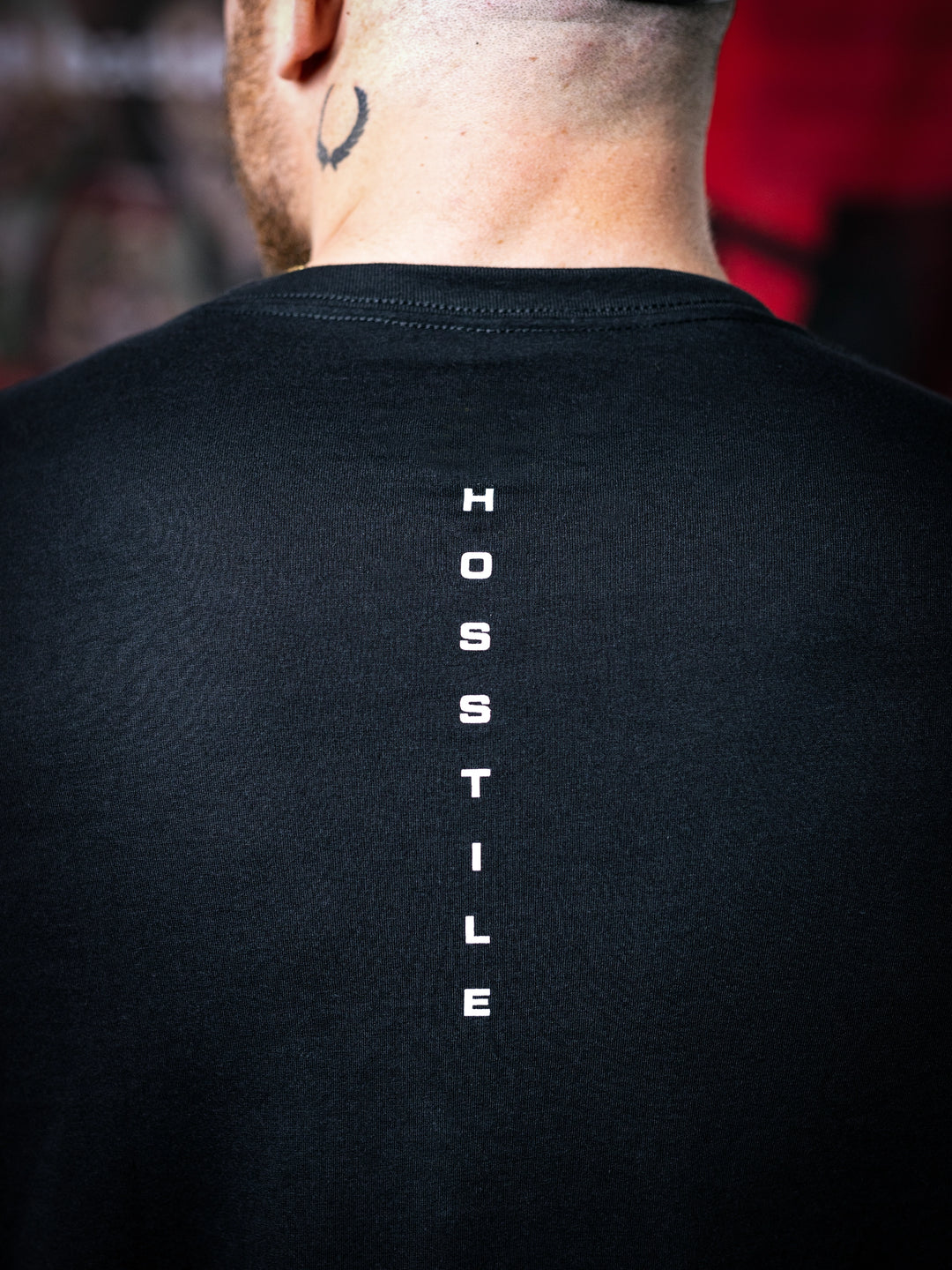 IFBB Pro Bodybuilder Martin Fitzwater wearing a black t-shirt with a graphic design and a cap, standing in a gym#color_black-african-sunrise