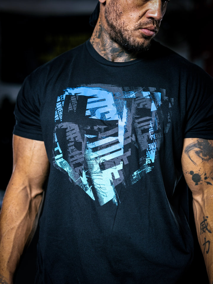 Bodybuilder Ben Chow wearing a black t-shirt with a graphic design and a cap, standing in a gym.#color_black-ocean