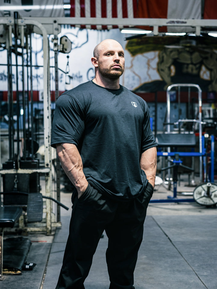 Bodybuilder Martin Fitzwater wearing the Shield Athletic Tee in the gym#color_black