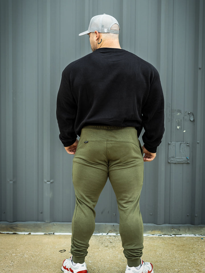 Martin Fitzwater wearing joggers in the gym#color_military-green