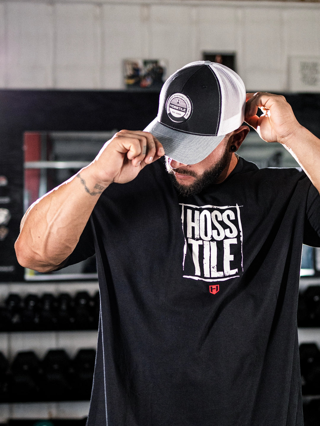 Bodybuilder wearing Tagline Richardson Trucker Hat in Gym#color_black-white