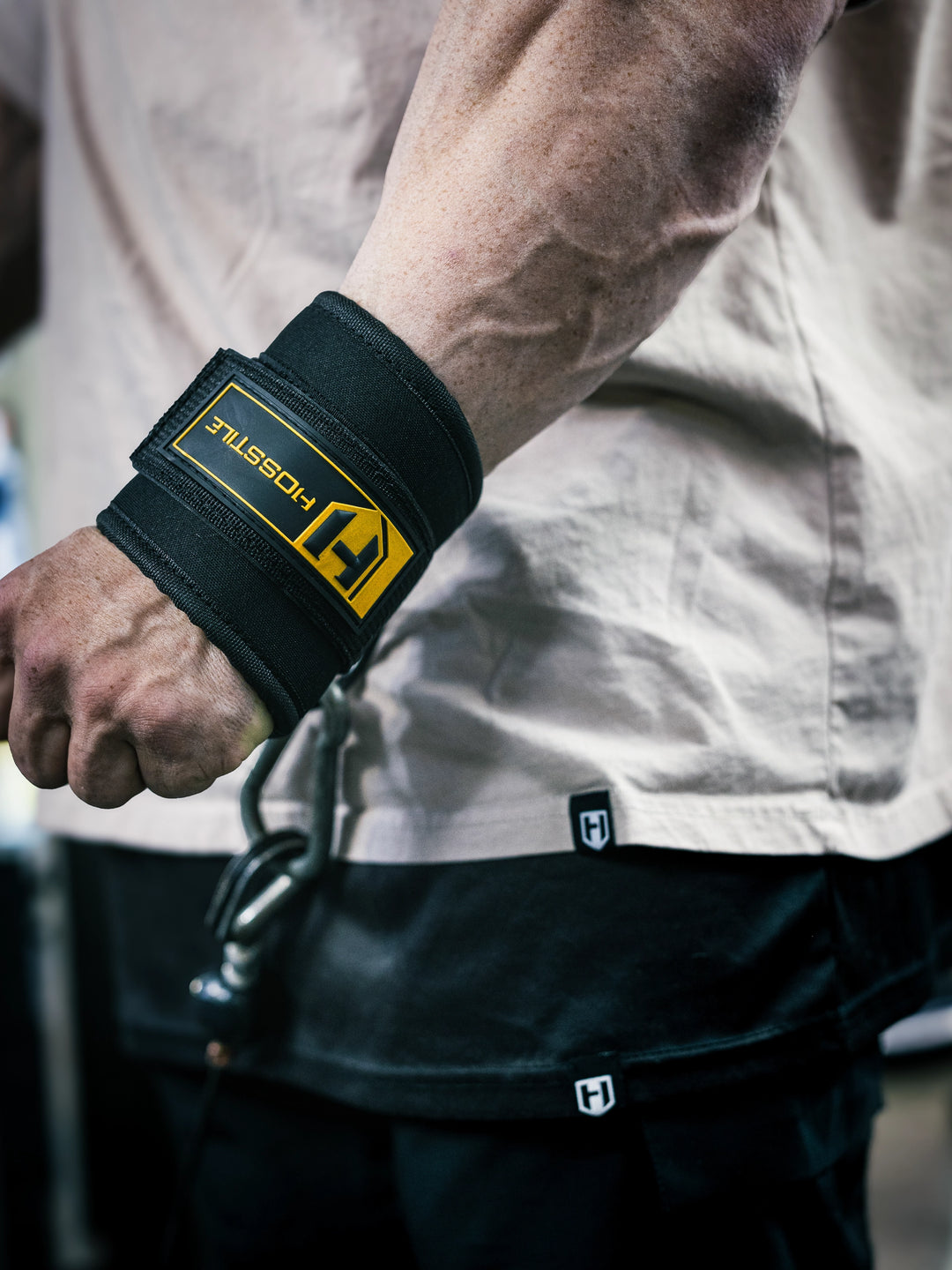 Bodybuilder Martin Fitzwater wearing Hosstile Ankle/Wrist Cuff for cable machine exercises in the gym