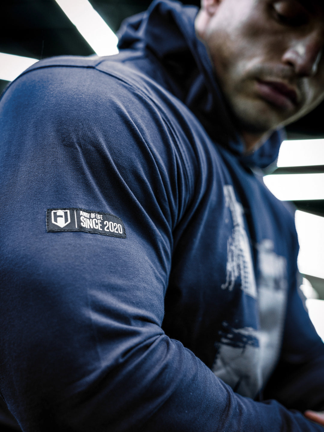 IFBB Pro Bodybuilder Martin Fitzwater wearing a navy hoodie and cap in a gym setting#color_navy