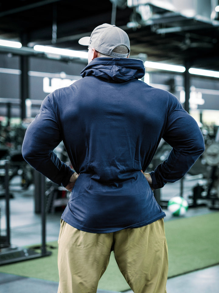 IFBB Pro Bodybuilder Martin Fitzwater wearing a navy hoodie and cap in a gym setting#color_navy