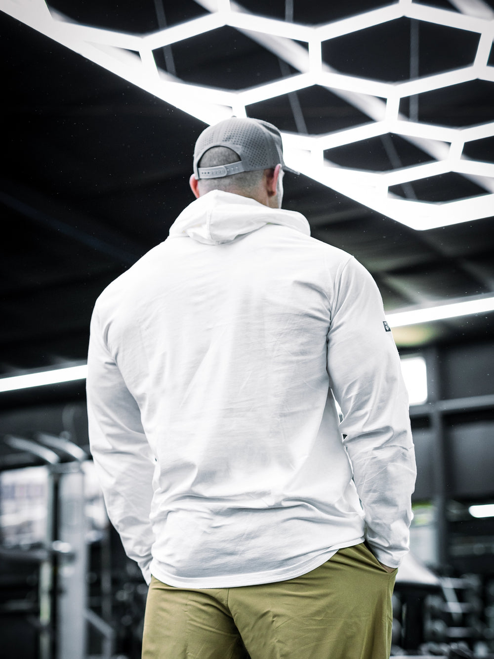 IFBB Pro Bodybuilder Martin Fitzwater wearing a white hoodie and cap in a gym setting#color_white