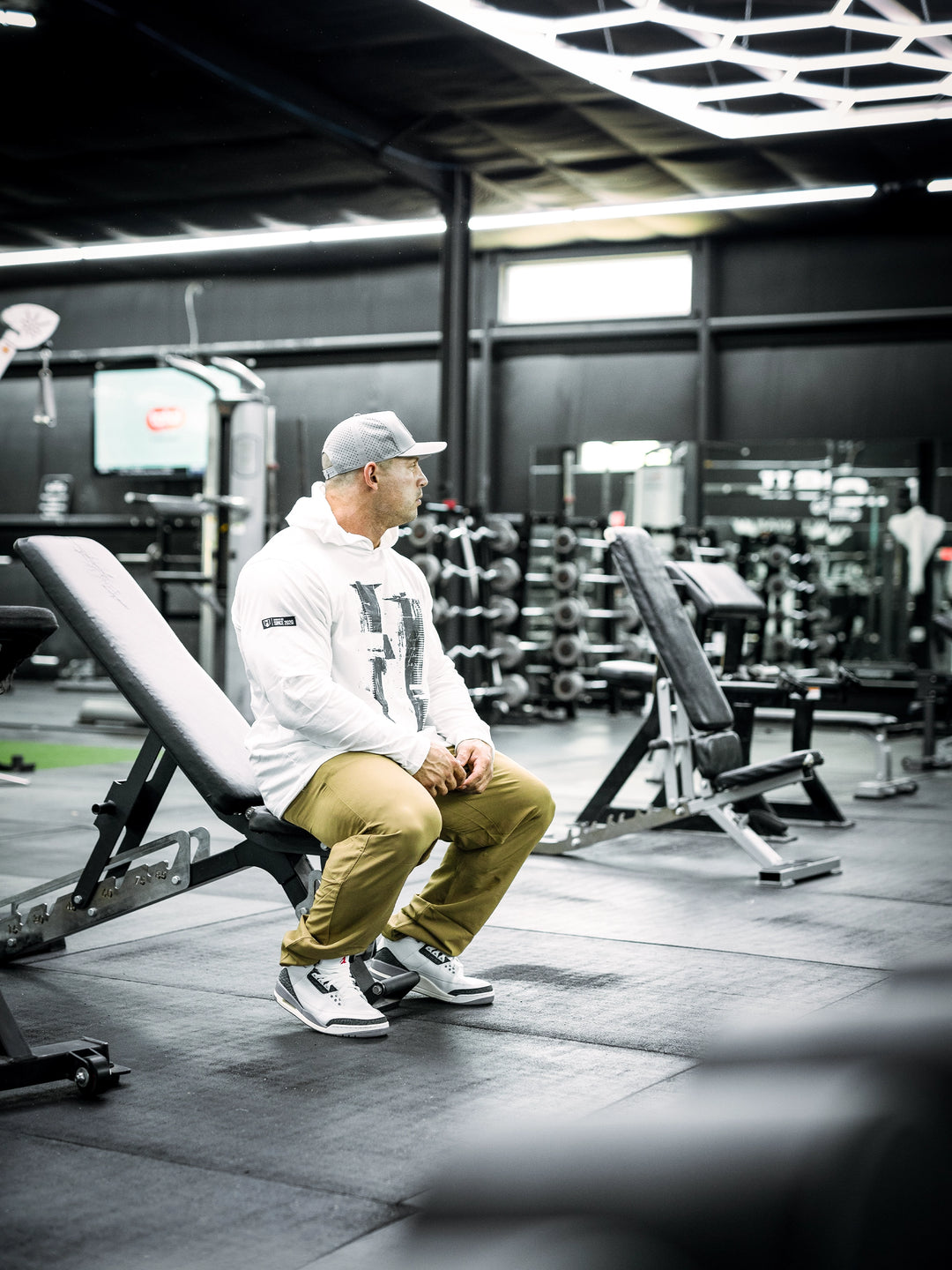 IFBB Pro Bodybuilder Martin Fitzwater wearing a white hoodie and cap in a gym setting#color_white