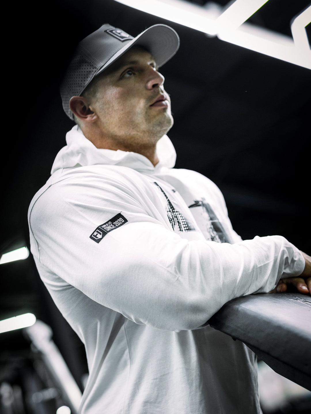 IFBB Pro Bodybuilder Martin Fitzwater wearing a white hoodie and cap in a gym setting#color_white