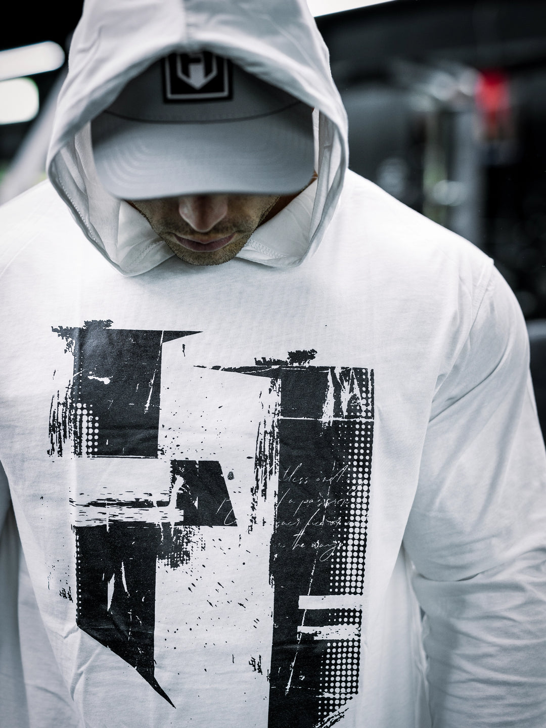 IFBB Pro Bodybuilder Martin Fitzwater wearing a white hoodie and cap in a gym setting#color_white